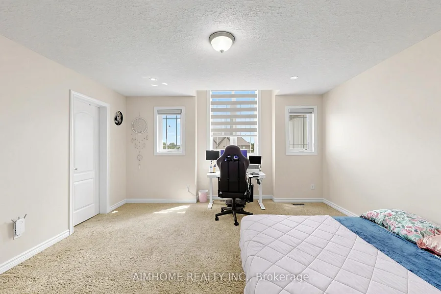 Spacious primary bedroom with multiple windows